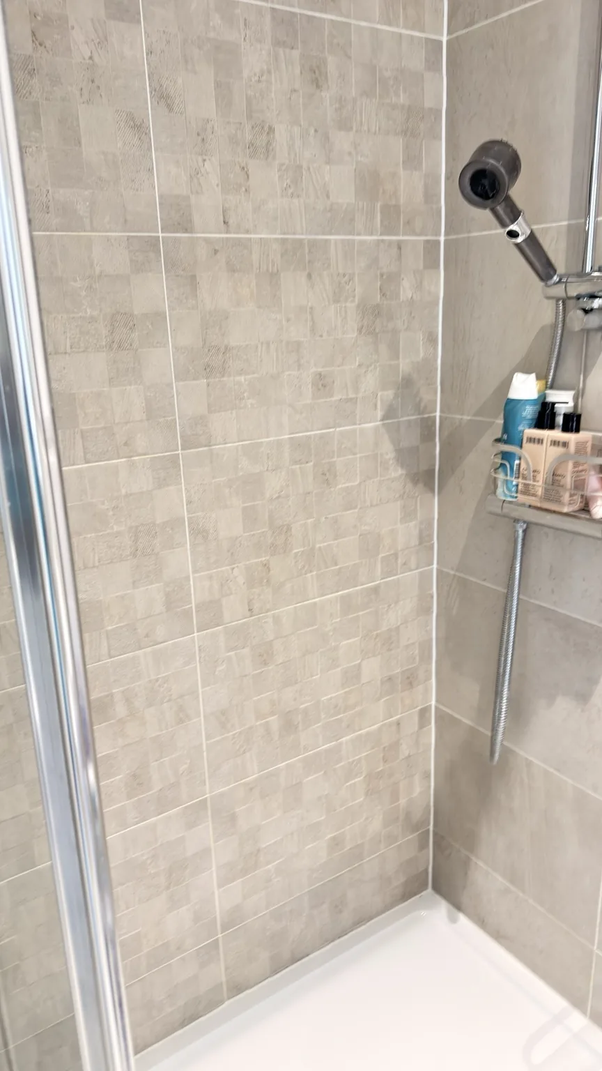 Clean shower tiles and enclosure after bathroom cleaning